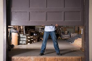 man physically lifting up garage door