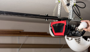 Specialist replacing a lightbulb in mounted garage door opener