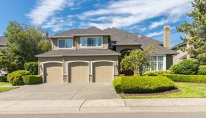 Beautiful house with three tan garage doors